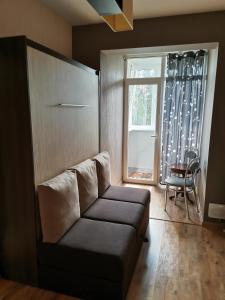 uma sala de estar com um sofá e uma janela em Sunny apartment Kėdainiai em Kėdainiai