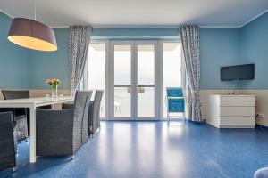 ein Esszimmer mit blauen Wänden sowie einem Tisch und Stühlen in der Unterkunft Laguna Seeappartements in Neukieritzsch