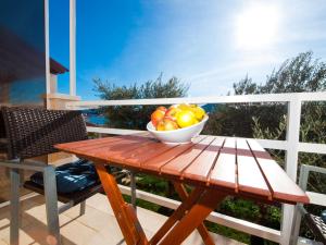 a bowl of fruit on a wooden table on a balcony at Apartments F & P in Dubrovnik
