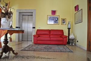 カルディエーロにあるHotel Ristorante Bruscoのリビングルーム(赤いソファ、テーブル付)