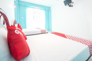 a bedroom with a bed with red pillows on it at OYO Hotel Estacion,José Cardel,Parque Central Revolución in José Cardel