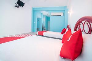 ein Schlafzimmer mit roten Kissen und einem weißen Bett in der Unterkunft OYO Hotel Estacion,José Cardel,Parque Central Revolución in José Cardel