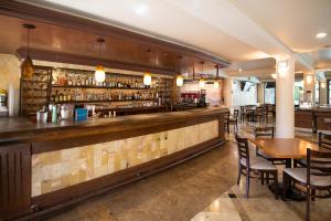 a bar in a restaurant with a table and chairs at Collection O Las Iglesias, Cholula in Cholula