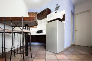 a small kitchen with a white refrigerator and a counter at Invernadero Inn in Veracruz