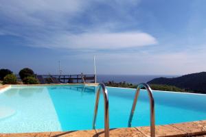 una piscina azul con vistas al océano en CAROLE F2, en Sainte-Lucie de Porto-Vecchio