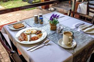 a table with a plate of food and a cup of coffee at At Heritage House in St Lucia