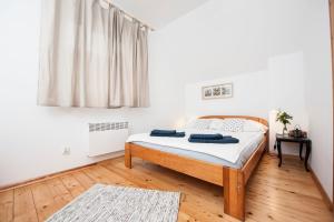 a bedroom with a bed with white sheets and a window at Pomeranka Domki Ustka in Ustka