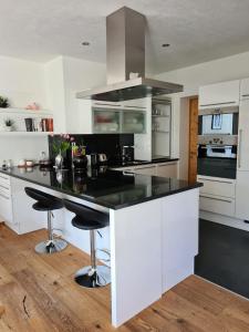 a kitchen with a black counter top and white cabinets at Chasa Scandella Apartment Tanja in Sent