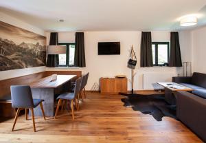 a living room with a table and chairs and a couch at Chalet Resort Montafon I - Chalets & Chalet-Apartments in Sankt Gallenkirch +165 photos