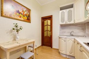 a kitchen with a sink and a table with chairs at Apartment Marata 10 in Saint Petersburg