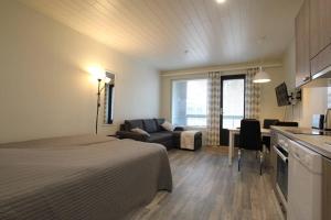um quarto com uma cama, uma cozinha e uma sala de estar em Auringonlasku em Kalajoki