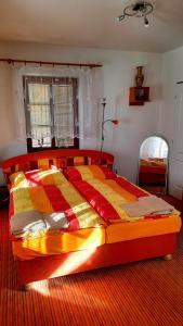 a bedroom with a bed with a colorful quilt on it at Penzion na Figleně in Slatinice