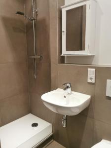 a bathroom with a sink and a toilet and a mirror at Apartment "Lyon" in Korschenbroich