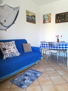 a living room with a blue couch and a table at Lu Bagnu Castelsardo La Baja dei Tramonti in Castelsardo