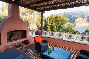 a patio with a couch and a fireplace at Villa sur le lac Bin el ouidane in Aït Irizane