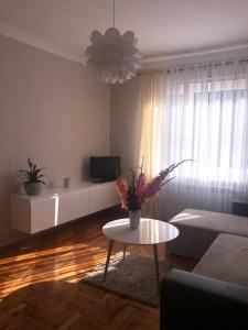 a living room with a vase of flowers on a table at Łapacz Snów II in Tylicz