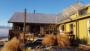 a yellow house with a porch and a deck at Forest Lodge in Castle Hill