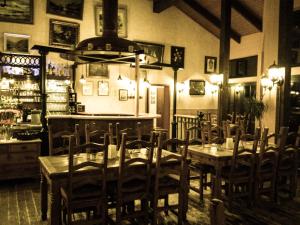 Arzbach的住宿－老啤酒屋酒店，一间带桌椅的餐厅和一间酒吧