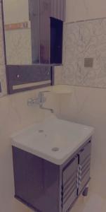 a bathroom with a sink and a mirror at شاليهات لودج in Al Humaizah