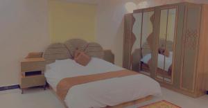 a bedroom with a bed and a large mirror at شاليهات لودج in Al Humaizah