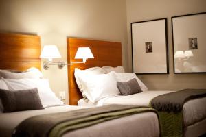 a hotel room with two beds and two mirrors at The Inn on Whitworth in Brookhaven