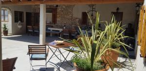 un patio con mesa, sillas y plantas en Rooms & Apartment STELIO, en Loborika