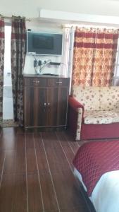 a hotel room with a sink and a tv at Rosewood Estate in Chail