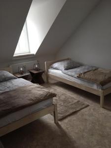 a attic room with two beds and a window at Schmidtapartment in Weimar