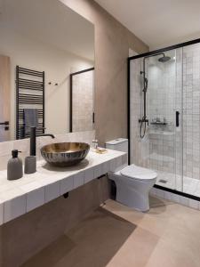 La salle de bains est pourvue d'un lavabo, de toilettes et d'une douche. dans l'établissement Muse Urban Suites, à Athènes