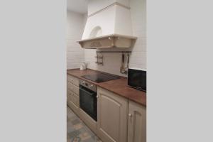 a kitchen with white cabinets and a stove top oven at Casa Mercedes. Laguardia (Alava) in Laguardia