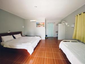 una camera con 2 letti e un pavimento in legno di Thmorda Riverview Resort a Koh Kong