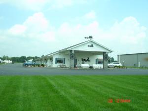 a building with a grass field in front of it at Der Ruhe Blatz Motel in Shipshewana