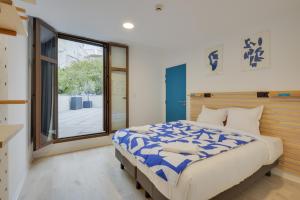 um quarto com uma cama grande e uma janela em The People - Marseille em Marselha