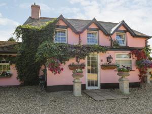 ein rosa Haus mit Blumentöpfen davor in der Unterkunft Park House in Llandrindod Wells