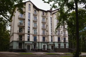 a large white building with trees in front of it at Кайзервальд Forus - апартаменти в Карпатах in Karpaty