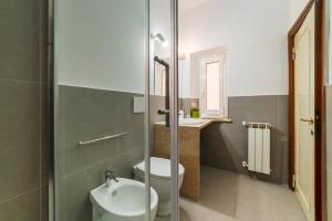 Un baño con inodoro, lavabo y ducha. en Casa dell'Arco - WelcomeToRhome, en Roma 29 fotos más