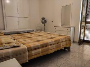 a bedroom with a bed and a dresser and a fan at Appartamento a pochi passi dal mare in Villapiana