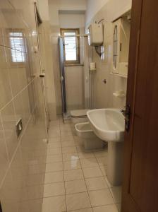 La salle de bains est pourvue d'un lavabo, de toilettes et d'une douche. dans l'établissement Appartamento a pochi passi dal mare, à Villapiana