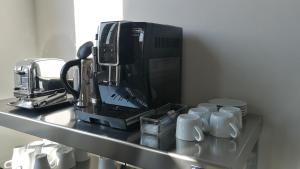 a kitchen counter with a coffee maker and coffee cups at 5&5 Rooftop in Clermont-Ferrand