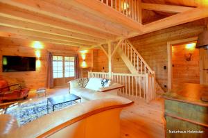 a living room with a couch and a staircase in a cabin at Naturhaus Innviertel 