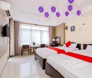 twee bedden in een kamer met paarse ballonnen aan het plafond bij Sao Biển Hotel in Vung Tau