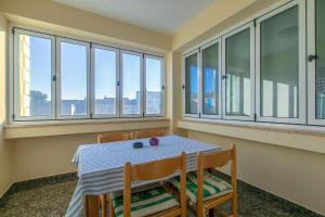 a dining room with a table and chairs and windows at B&B-Ld in Pula