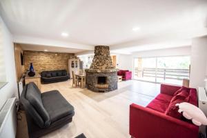 a living room with a red couch and a fireplace at Vila Zen in Slănic-Moldova