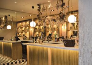 a bar in a restaurant with a counter and lights at The Hotel at Mill Farm in Kirkham