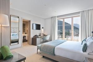a hotel room with a bed and a desk with a view at Hotel AMI Budva Petrovac in Petrovac na Moru