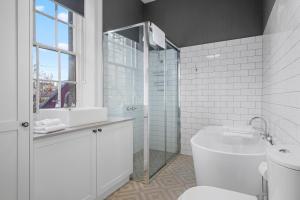 a white bathroom with a sink and a toilet at Cromwell Apartment - 3 Red Doors Battery Point in Hobart