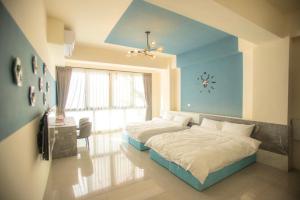 1 dormitorio con 2 camas y reloj en la pared en A Day in Lukang Homestay, en Lukang