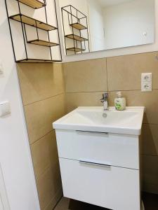 łazienka z białą umywalką i lustrem w obiekcie Heimathafen Prora, 3.OG mit Meerblick w mieście Binz +9 zdjęć