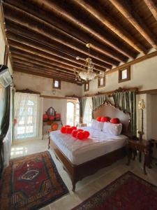 a bedroom with a large bed with red pillows at Kasr-ı Canan in Halfeti