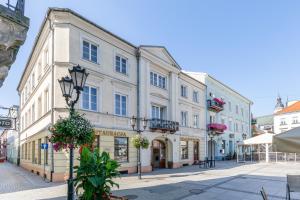 un grande edificio bianco su una strada con fiori di Kamienica Szefferów 1848 r. a Piotrków Trybunalski